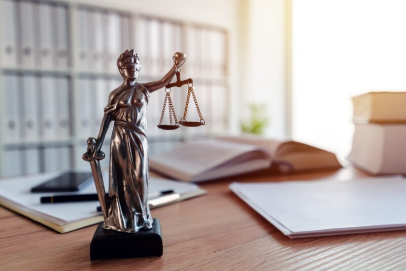 scales of justice sitting on a desk in a law firm office