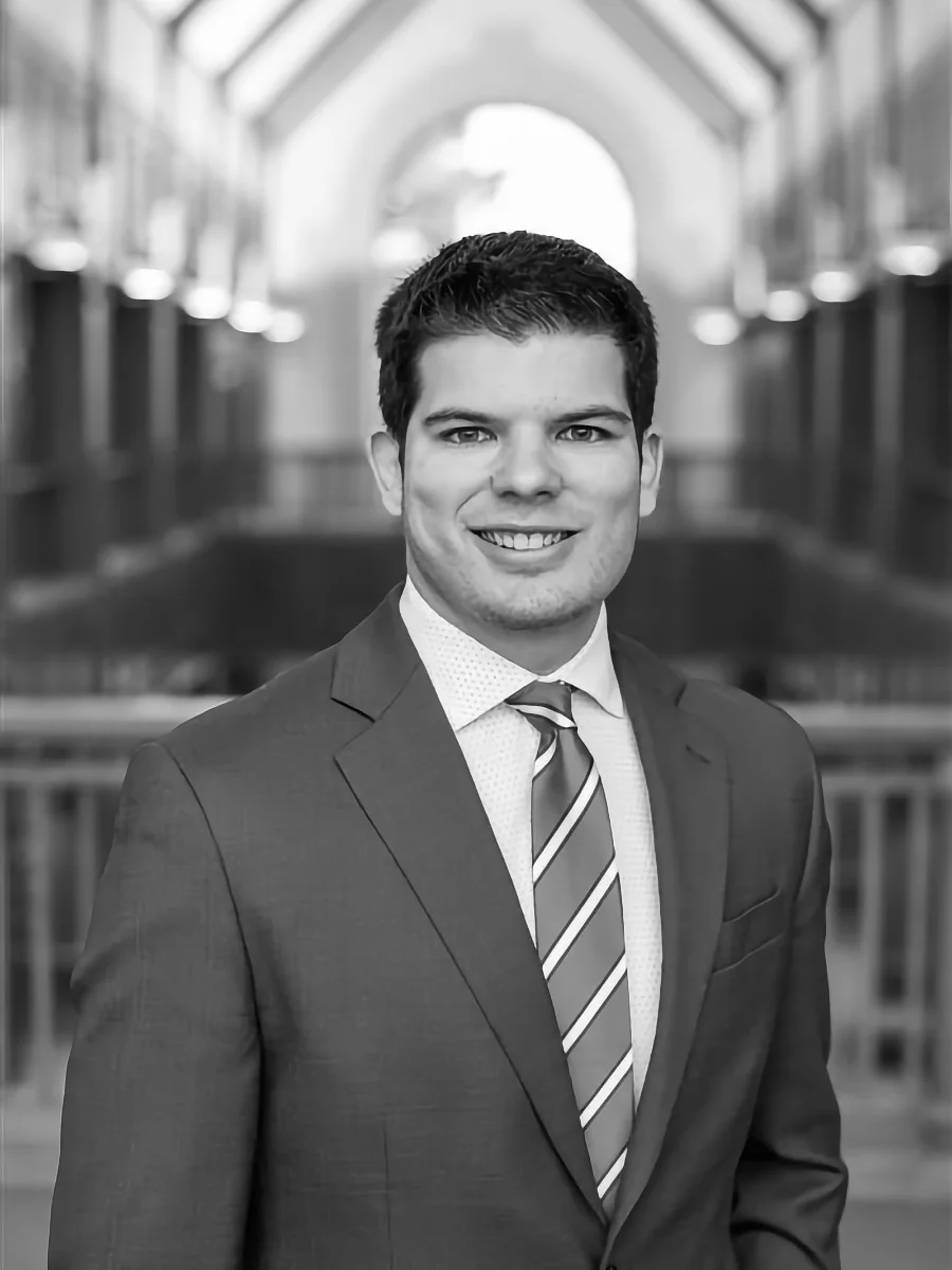 Attorney Josh Jacobson, a smiling man in suit and tie with a blurred court room behind him