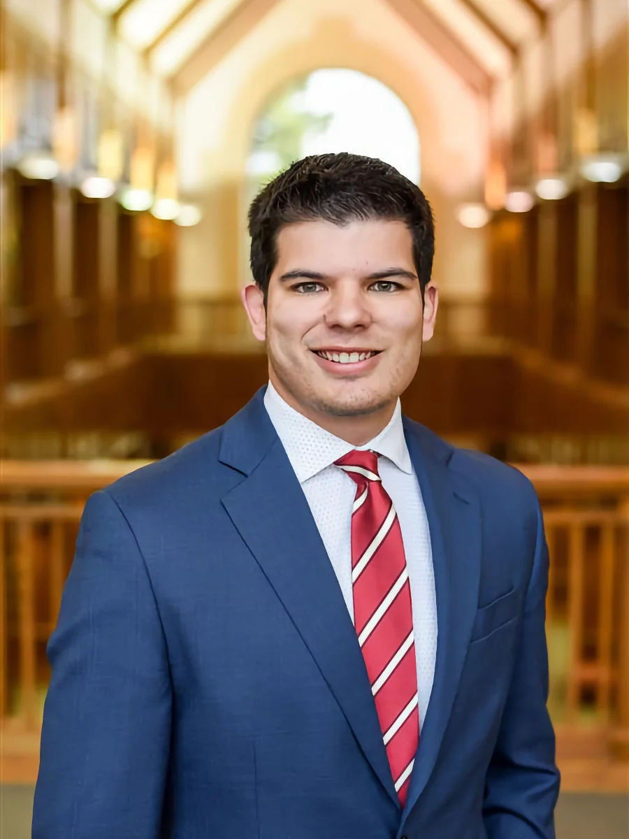 Attorney Josh Jacobson, a smiling man in suit and tie with a blurred court room behind him